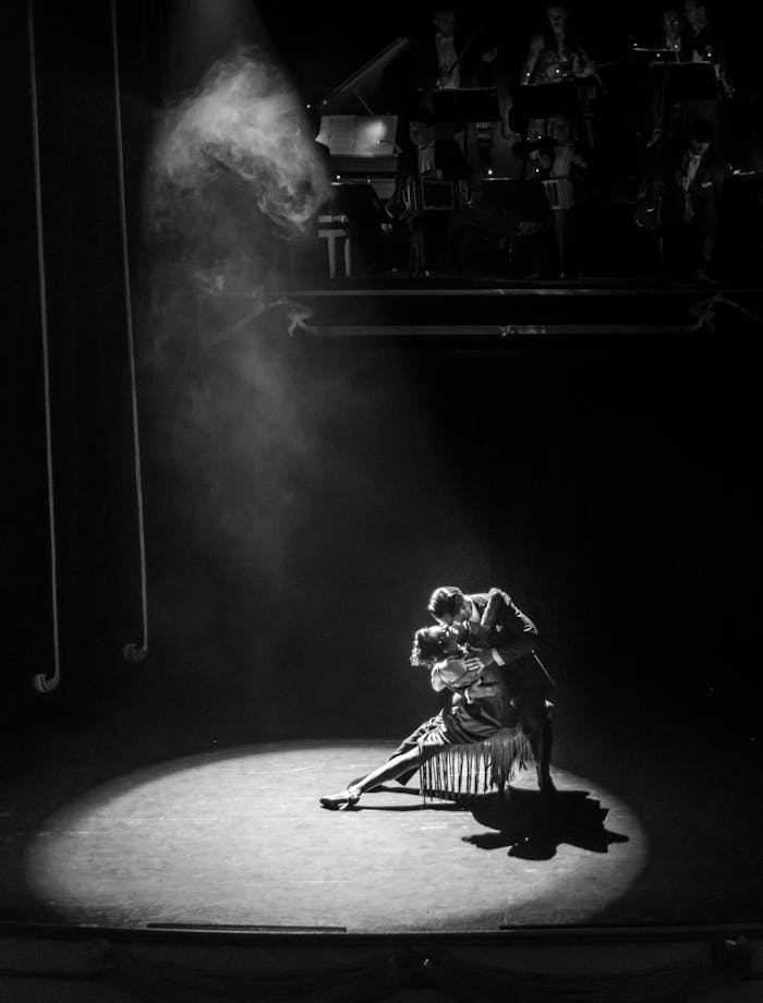 Captivating black and white image of a dramatic dance performance on stage.